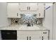 Bright kitchen featuring white cabinets, granite countertops, and modern tile backsplash at 7702 Dornock Dr, Indianapolis, IN 46237