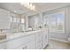 Spa-like bathroom features dual sinks, a modern mirror, white cabinets, quartz countertops, and a glass-enclosed shower at 8180 E 116Th St, Fishers, IN 46038