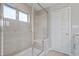 Elegant bathroom featuring a glass-enclosed shower with light stone-look tile, a built-in bench, and a bright window at 8180 E 116Th St, Fishers, IN 46038