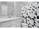 Clean, modern bathroom features white cabinets, a quartz countertop, and a stylish geometric shower curtain at 8180 E 116Th St, Fishers, IN 46038