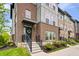 Close up of a charming townhouse with a brick facade, a wreath on the door, and landscaped front yard at 8180 E 116Th St, Fishers, IN 46038