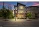 Charming townhouse complex with modern design and brick accents, enhanced by decorative street lighting at dusk at 8180 E 116Th St, Fishers, IN 46038