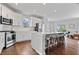 The modern kitchen features stainless appliances, white cabinets, a kitchen island, and bar stool seating, perfect for gatherings and entertaining at 8180 E 116Th St, Fishers, IN 46038