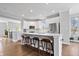 This bright, modern kitchen features stainless appliances, white cabinets, a kitchen island, bar stool seating, and wood flooring at 8180 E 116Th St, Fishers, IN 46038