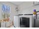 Bright laundry room with front load washer and dryer, wire shelves, and a window with outdoor views at 8180 E 116Th St, Fishers, IN 46038