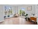 Sunlit living area featuring a comfortable chair, wood floors, large windows, and stylish decor with many plants at 8180 E 116Th St, Fishers, IN 46038
