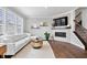 Bright living room features a white sectional sofa, modern fireplace, and large windows with great natural light at 8180 E 116Th St, Fishers, IN 46038