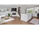 Open-concept living area featuring a kitchen island, fireplace, staircase, hardwood floors, and a cozy seating area at 8180 E 116Th St, Fishers, IN 46038