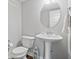 Cozy powder room featuring a pedestal sink, round mirror, and decorative accents at 8180 E 116Th St, Fishers, IN 46038