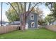 Charming two-story home featuring lush green grass, wooden fence, and a beautiful tree at 838 N Tacoma Ave, Indianapolis, IN 46201