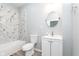 Well-lit bathroom featuring marble-look shower walls, round mirror, and white vanity at 838 N Tacoma Ave, Indianapolis, IN 46201