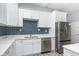 Stylish kitchen boasts white cabinetry, stainless appliances, and a striking backsplash at 838 N Tacoma Ave, Indianapolis, IN 46201