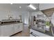 Modern kitchen with white cabinets, black countertops, stainless steel appliances, and wood-look flooring at 91 Crestview Dr, Greenwood, IN 46143