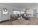 Open concept living room with gray sectional sofa, large windows, and adjacent dining area at 91 Crestview Dr, Greenwood, IN 46143