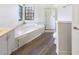 Bright bathroom with a shower, soaking tub, vanity, and wood look flooring at 9162 Hadway Dr, Indianapolis, IN 46256