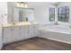 Bathroom with double vanity sinks, a large mirror, a window, and a jacuzzi at 9162 Hadway Dr, Indianapolis, IN 46256