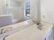 Bright bathroom featuring double sinks with a large mirror and a bathtub with shower and window at 9162 Hadway Dr, Indianapolis, IN 46256