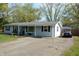 Light blue single-story house, with a long driveway and a small front yard and trees in the background at 10360 Wilson Rd, Brownsburg, IN 46112