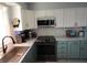Kitchen with white and green cabinets, countertops, stainless steel sink and appliances at 10360 Wilson Rd, Brownsburg, IN 46112