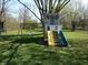 Backyard view of a ' playground with a playset, swings, and slide surrounded by a grassy yard at 10360 Wilson Rd, Brownsburg, IN 46112