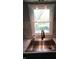 Modern stainless steel sink with matte black faucet beneath a window with a backyard view and gray backsplash at 10360 Wilson Rd, Brownsburg, IN 46112