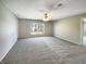Spacious carpeted bedroom featuring neutral walls, a ceiling fan, and a view to the outdoors at 10376 Alice Ct, Fishers, IN 46038