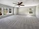 Large, carpeted bedroom with ample natural light from multiple windows and a ceiling fan at 10376 Alice Ct, Fishers, IN 46038