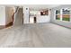 Bright, open-concept living room with plush carpets, a staircase, and an open kitchen at 10376 Alice Ct, Fishers, IN 46038