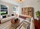 Bright living room with hardwood floors, a white sofa, decorative shelving, and plenty of natural light at 10376 Alice Ct, Fishers, IN 46038