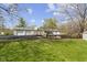 Large backyard featuring a patio, manicured lawn, mature trees, and a detached garage at 10421 Hillsdale Dr, Carmel, IN 46032