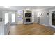 Open concept living area with hardwood flooring, stone fireplace, built-in shelves, and patio access at 10421 Hillsdale Dr, Carmel, IN 46032