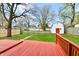 Exterior shot of a home with a red deck and spacious fenced in backyard at 106 S Wayburn St, Indianapolis, IN 46229