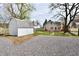 Home exterior featuring a backyard, gravel parking area, and an exterior building at 106 S Wayburn St, Indianapolis, IN 46229