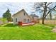 Home exterior featuring a red deck, green grass, and a fenced in yard at 106 S Wayburn St, Indianapolis, IN 46229