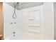 White bathtub with shower features modern fixtures and a built-in toiletry caddy at 106 S Wayburn St, Indianapolis, IN 46229