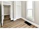 Bright bedroom features wood floors, closet, an open door, and natural light from a large window at 106 S Wayburn St, Indianapolis, IN 46229