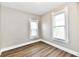 Bedroom with two windows providing plenty of natural light, plus wood-look floors and neutral walls at 106 S Wayburn St, Indianapolis, IN 46229