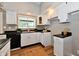 Bright kitchen featuring white cabinets, a black countertop, and wood-look floors at 106 S Wayburn St, Indianapolis, IN 46229
