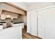 Spacious kitchen features white cabinetry, black countertops, and wood-look flooring near bi-fold closet at 106 S Wayburn St, Indianapolis, IN 46229