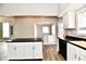 Bright kitchen features white cabinetry, black countertops, stainless steel appliances, and wood-look flooring at 106 S Wayburn St, Indianapolis, IN 46229
