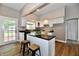 Well-lit kitchen with white cabinets, a kitchen island, and a view to the backyard at 106 S Wayburn St, Indianapolis, IN 46229
