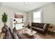 Bright living room featuring neutral gray walls, hardwood-look flooring and a white fireplace at 106 S Wayburn St, Indianapolis, IN 46229