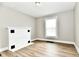 Bright room featuring a classic fireplace, neutral gray walls and hardwood-look flooring at 106 S Wayburn St, Indianapolis, IN 46229