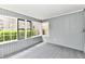 Enclosed sunroom featuring neutral gray walls and ceiling with multi-pane windows and carpet at 106 S Wayburn St, Indianapolis, IN 46229