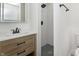 Updated bathroom featuring a wood vanity, modern fixtures, and a stylish black-tiled shower at 109 S 10Th S Ave, Beech Grove, IN 46107