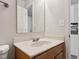 Bathroom with wood vanity, marble countertops, mirror, and modern fixtures at 10905 Amber Glow Ln, Indianapolis, IN 46229