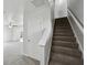 Bright entryway with carpeted staircase leading to the upper level and doorway to other rooms at 10905 Amber Glow Ln, Indianapolis, IN 46229