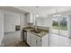 Kitchen with stainless steel sink and granite counters that opens to living room and sliding glass doors at 10905 Amber Glow Ln, Indianapolis, IN 46229