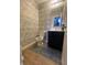 Powder room featuring decorative wallpaper, toilet, modern vanity with a dark finish and modern faucet at 11726 Zander Dr, Indianapolis, IN 46235