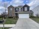 Two-story home with brick and siding, white garage door, and landscaped front yard at 11726 Zander Dr, Indianapolis, IN 46235